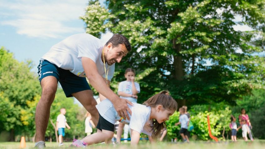 a man and a little girl playing with a frisbee